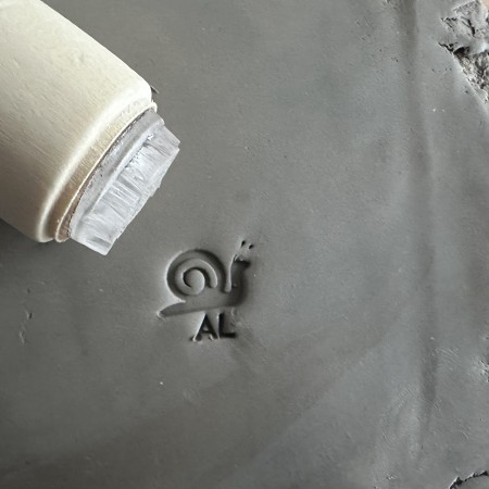 Personalized pottery stamp with initials and snail