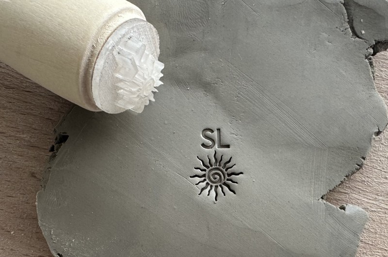 Personalized pottery stamp with initials and tribal sun